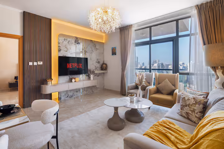 The Links East: The living room, the sofa under the chandelier, the television on the wall