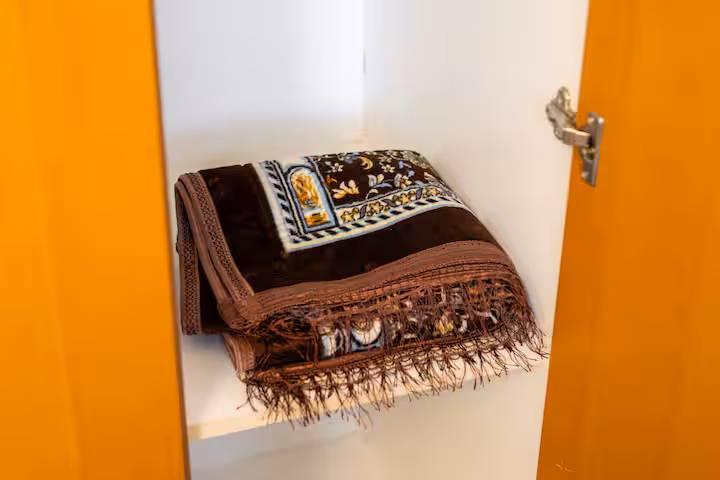 The Links East: A prayer mat, folded in the wardrobe