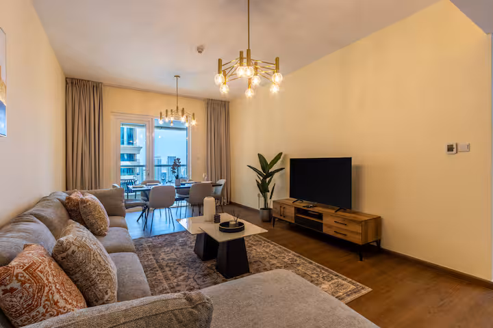 Sulafa Tower: The living room: a long grey corner sofa, the television, hardwood floor