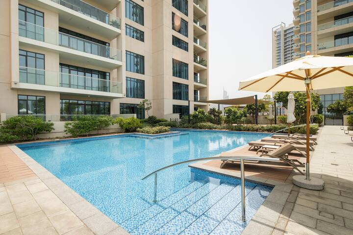 Vida Residences: The pool, sun loungers under umbrellas, the golf course beyond