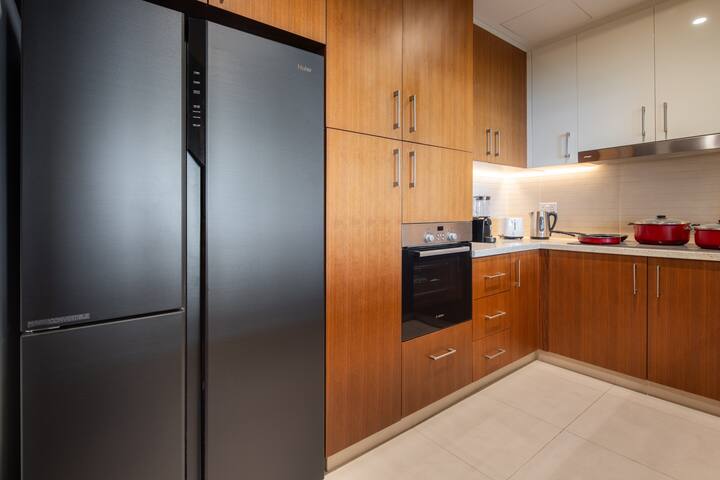 Vida Residences: The kitchen: dark fridge, oven, timber units