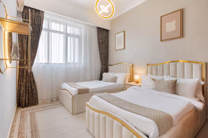 Vida Residences: Bedroom one, a king bed, gold and white